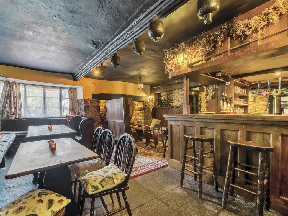 A pub interior with bar and tables at The Old Church House in Torbryan