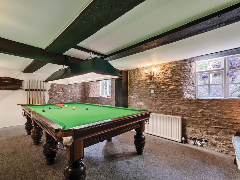 A game room with a pool table and cues at The Old Church House in Torbryan