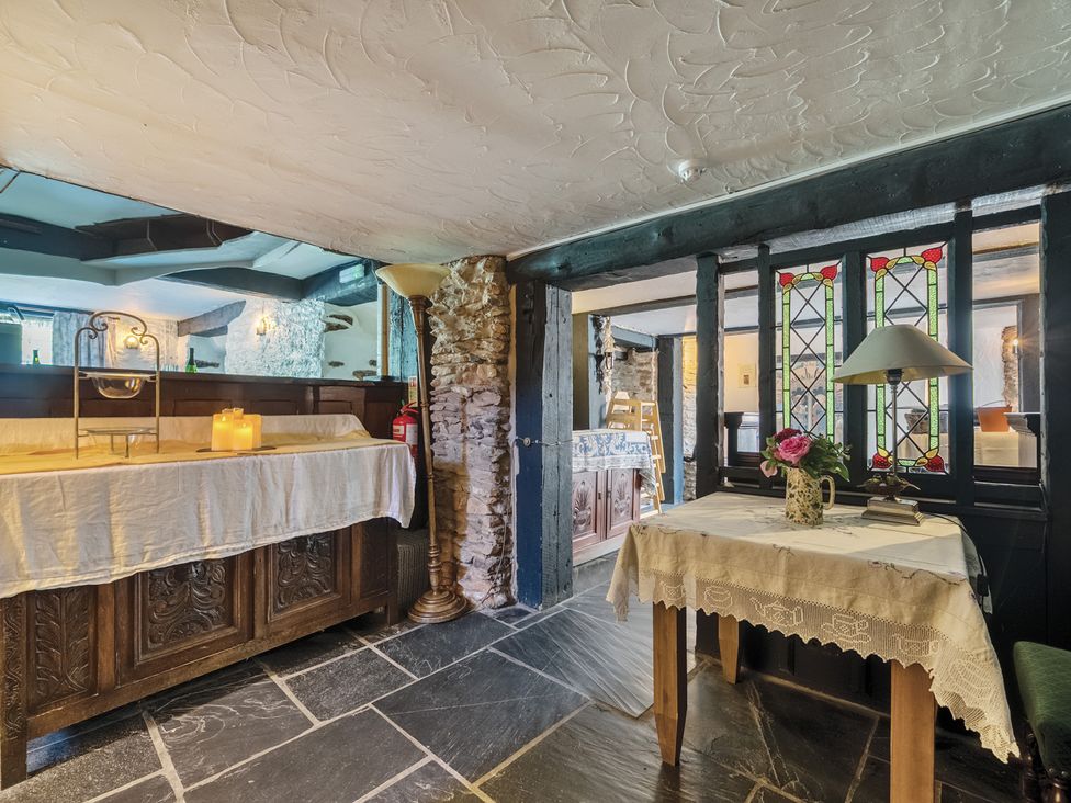 A reception area with a table and lamp at The Old Church House in Torbryan