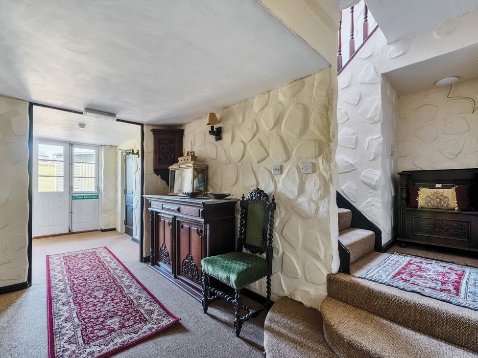 A hallway with a table and stairs at The Old Church House in Torbryan