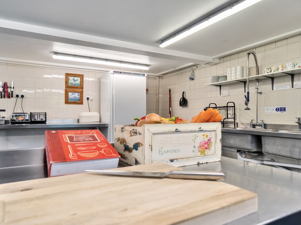 A kitchen with a refrigerator and utensils at The Old Church House in Torbryan