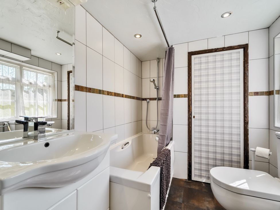 A bathroom with a sink, bathtub, toilet and shower at The Old Church House in Torbryan