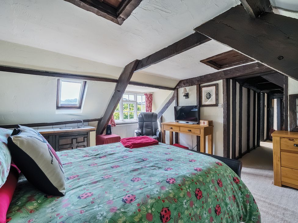 A bedroom with a bed and television at The Old Church House in Torbryan