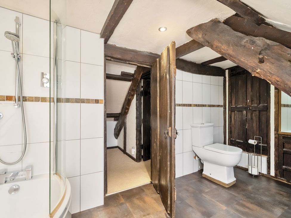 A bathroom featuring a shower, bathtub, and toilet at The Old Church House in Torbryan