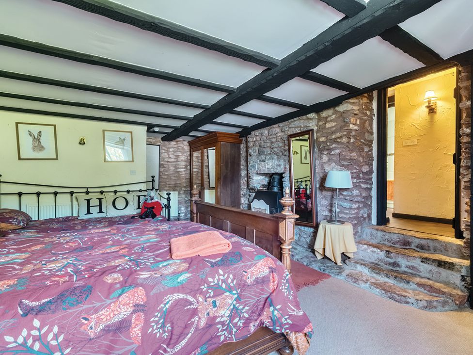 A bedroom with a bed and a mirror at The Old Church House in Torbryan