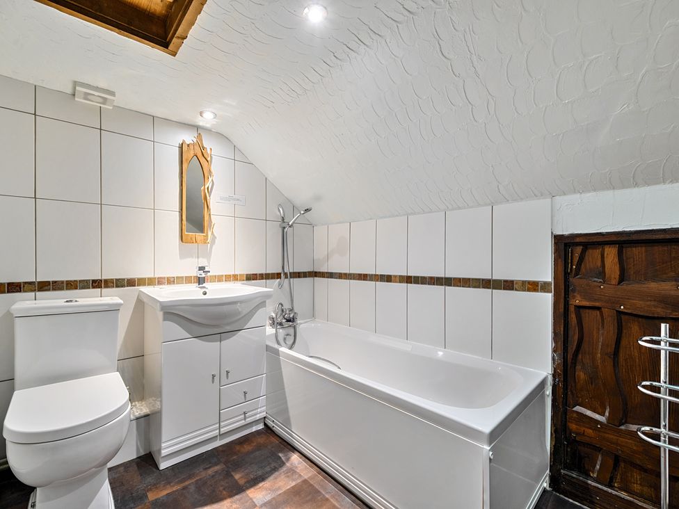 A bathroom with a bathtub, sink, and toilet at The Old Church House in Torbryan