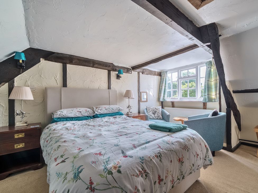 A bedroom with a bed and seating area at The Old Church House in Torbryan
