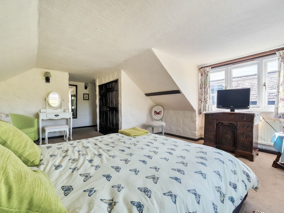 A bedroom with a bed and a television at The Old Church House in Torbryan