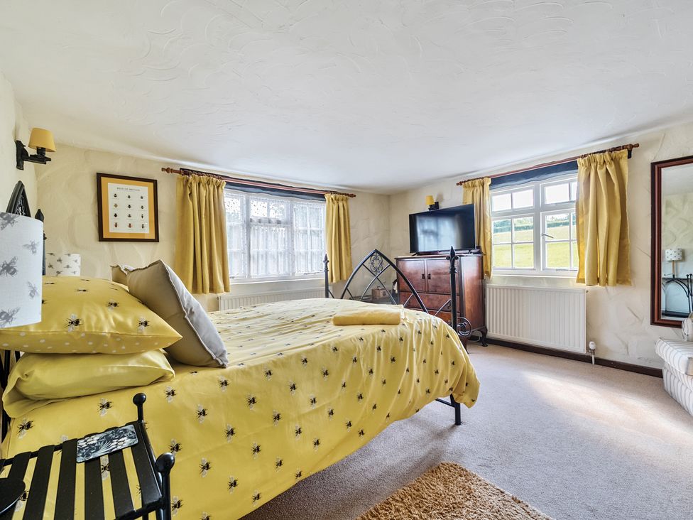 A bedroom with a bed and television at The Old Church House in Torbryan