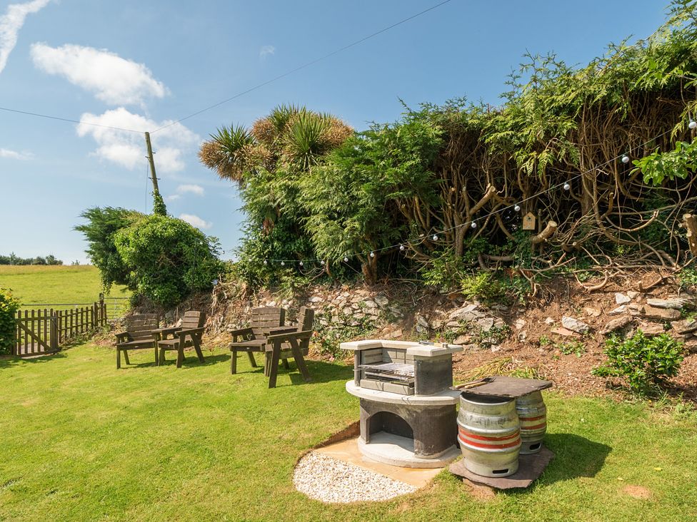 A garden with seating area and barbecue at The Old Church House in Torbryan