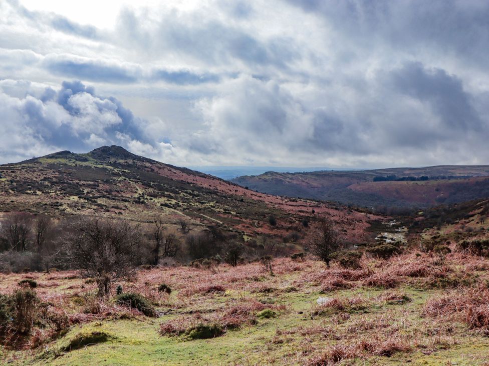 A landscape view of hills and trees under a cloudy sky at The Old Church House in Torbryan