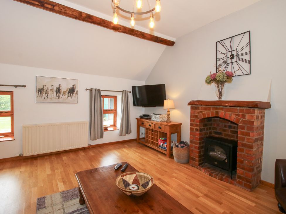 A living room with a television and fireplace at Old Hall Barn 3 Church Stretton