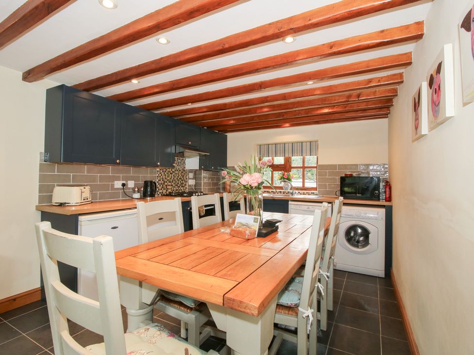 A kitchen with a table and appliances at Old Hall Barn 3 Church Stretton