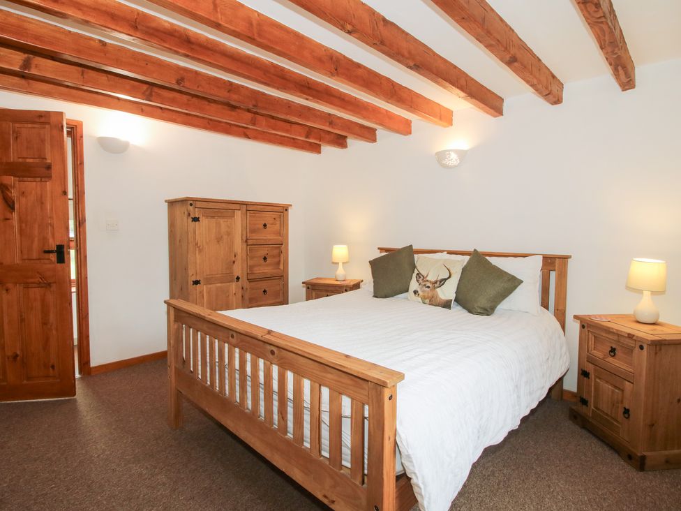 A bedroom with a bed, wardrobe, and nightstands at Old Hall Barn 3, Church Stretton