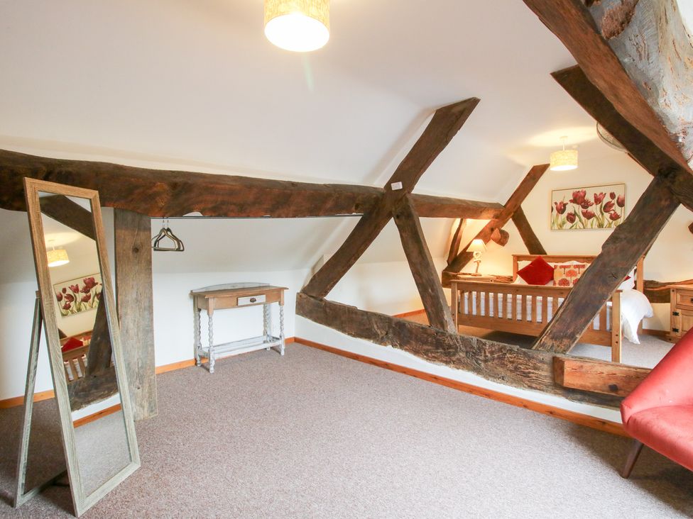A bedroom with a bed and wooden beams at Old Hall Barn 3 Church Stretton