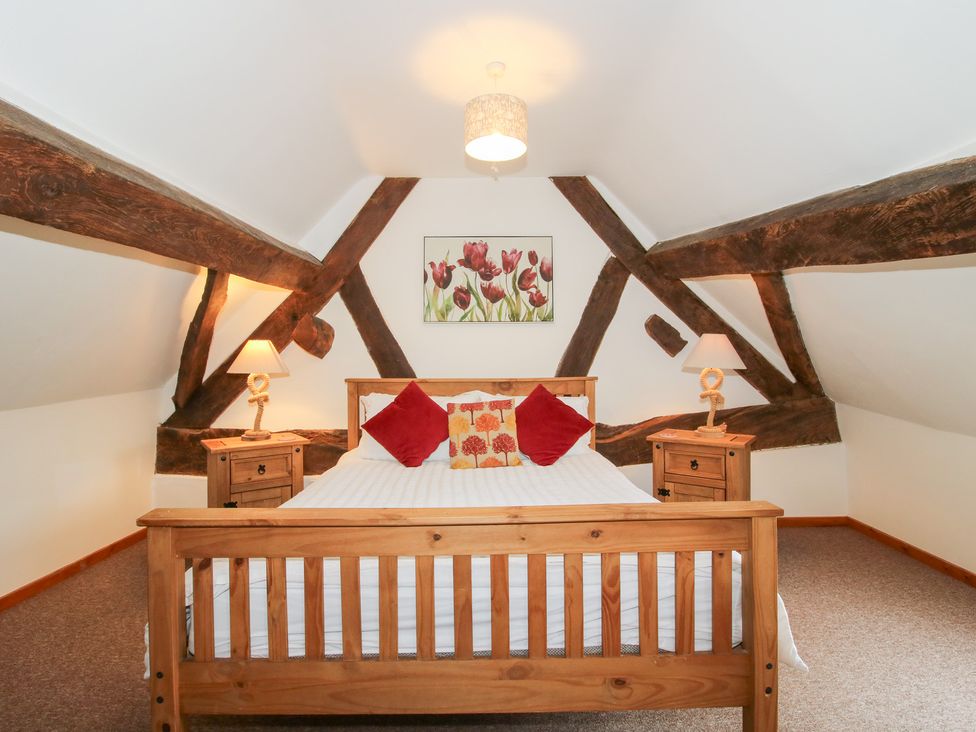 A bedroom with a double bed and wooden furniture at Old Hall Barn 3 Church Stretton
