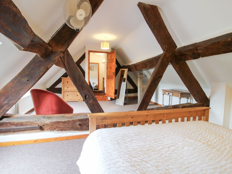 A bedroom with wooden beams and furniture at Old Hall Barn 3 in Church Stretton