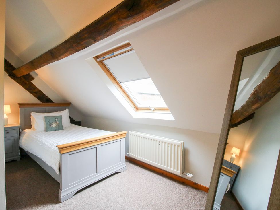 A bedroom with a bed and bedside table at Old Hall Barn 3 in Church Stretton