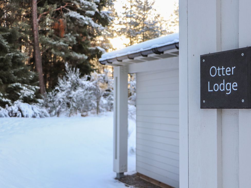 Entry view of Otter Lodge with snow and trees at Otter Lodge in Feshiebridge near Aviemore