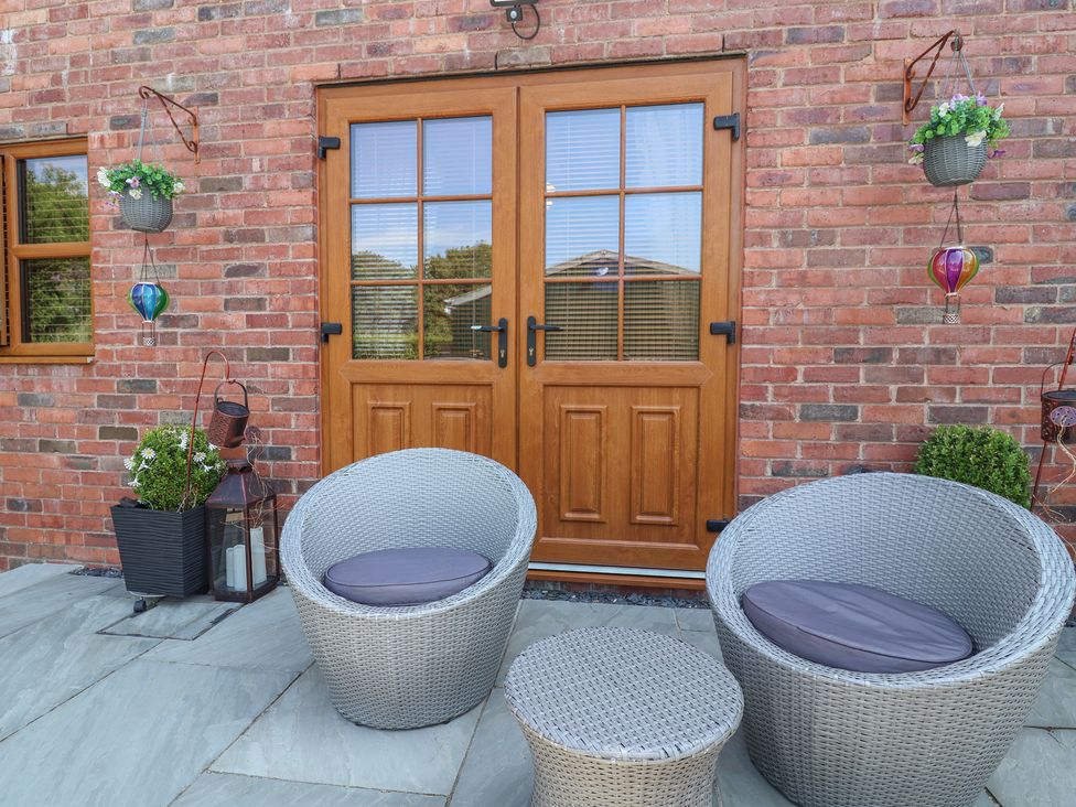 An outdoor seating area with chairs and table at Ash Farm Cottage in Lixwm near Caerwys