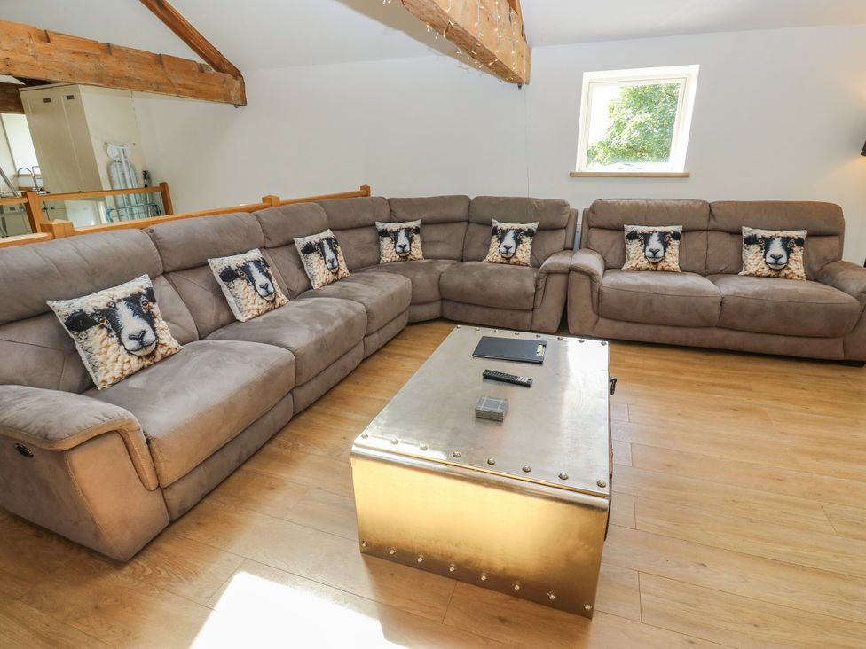 A living room with a sectional sofa and a coffee table at Upper House Barn (Saddleworth) in Delph