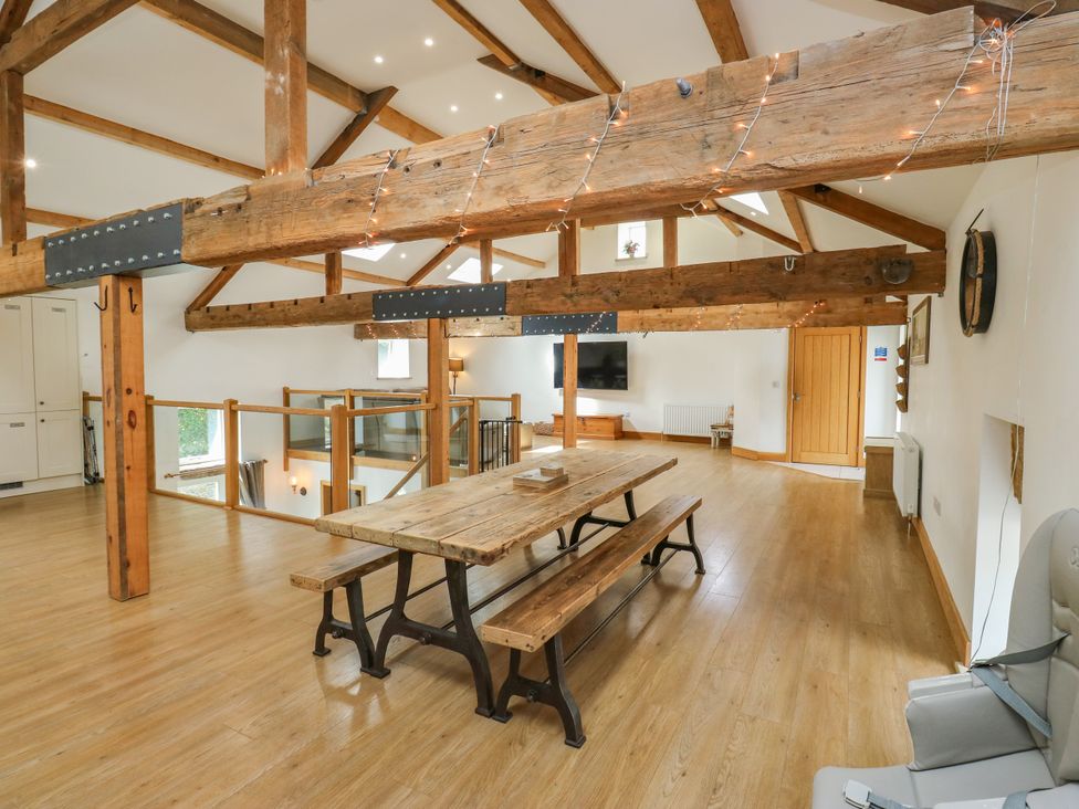 A dining room with a table and chairs at Upper House Barn (Saddleworth) Delph