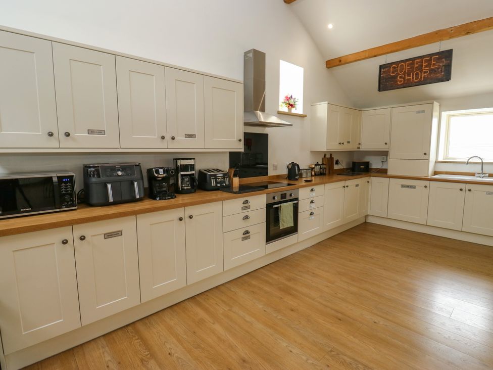 A kitchen with appliances and cabinets at Upper House Barn (Saddleworth) in Delph