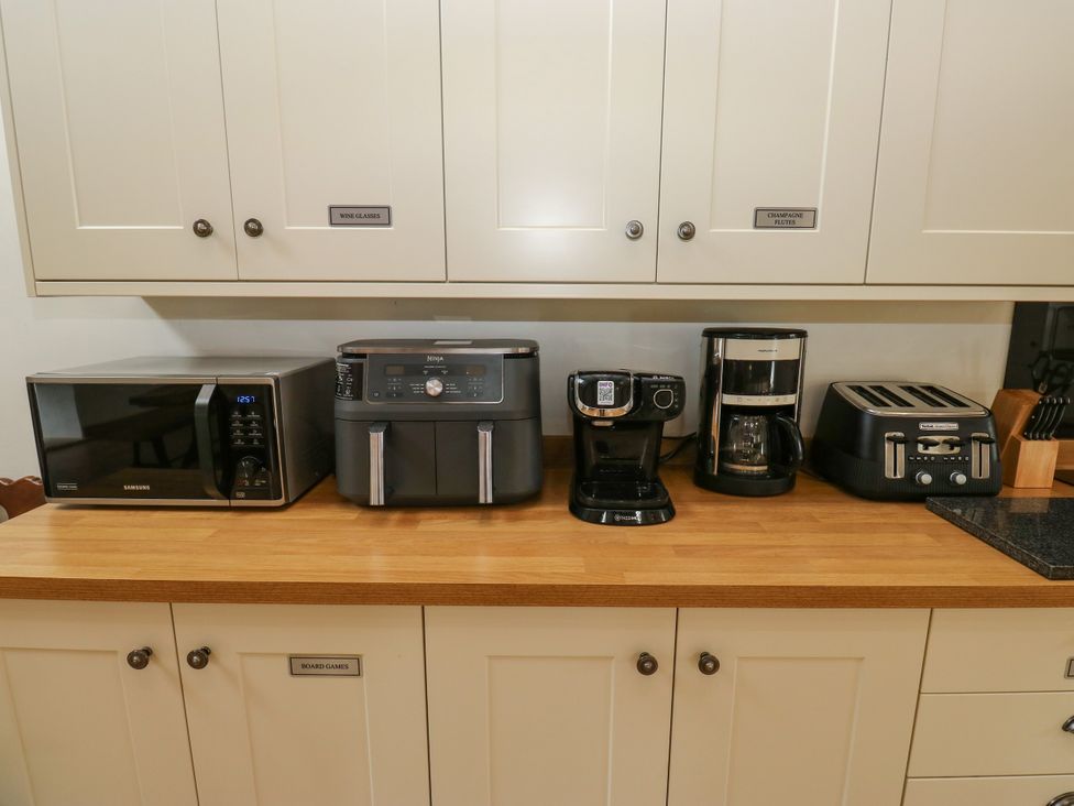 A kitchen with a microwave, air fryer, coffee maker, drip coffee maker, and toaster at Upper House Barn (Saddleworth) in Delph
