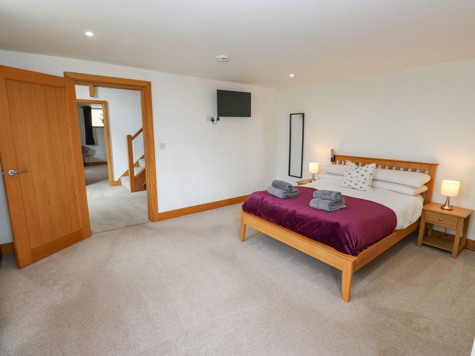 A bedroom with a bed and television at Upper House Barn (Saddleworth) Delph