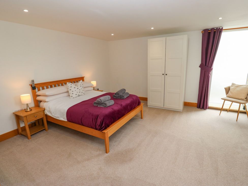 A bedroom with a bed and wardrobe at Upper House Barn (Saddleworth) Delph