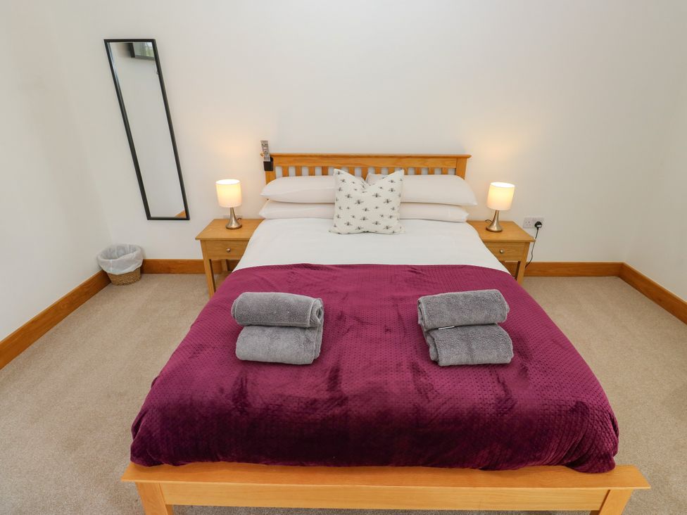 A bedroom with a bed and nightstand at Upper House Barn (Saddleworth) in Delph