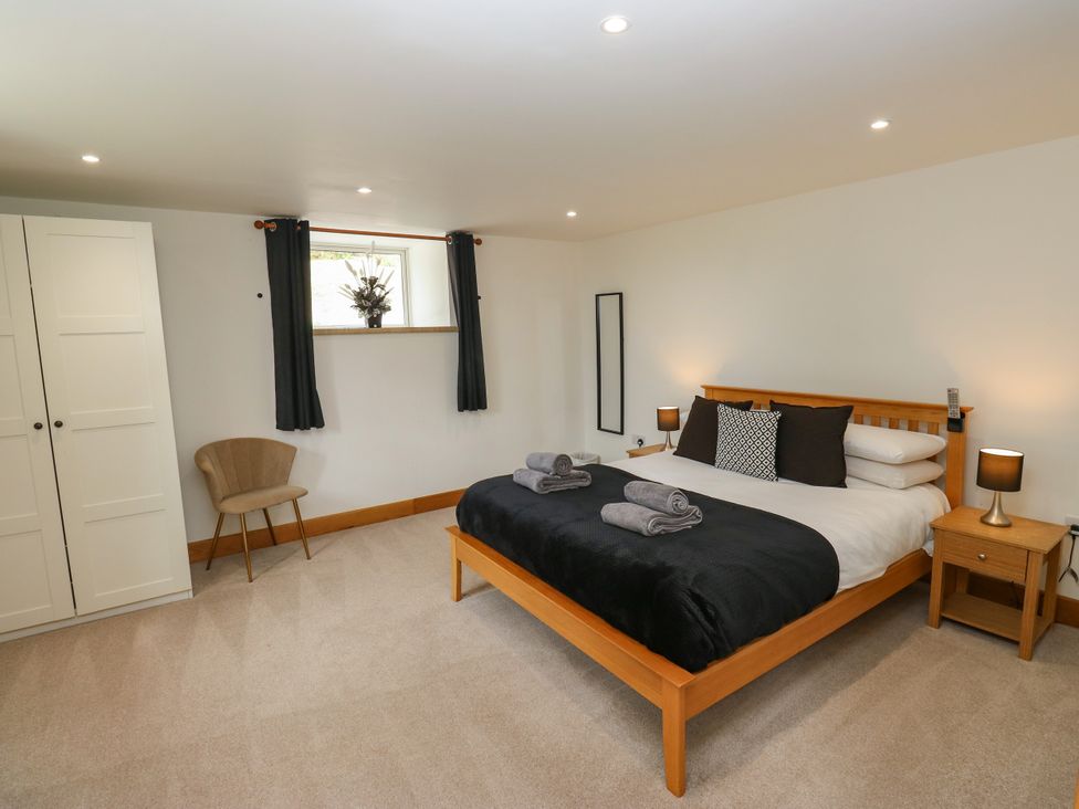 A bedroom with a bed and wardrobe at Upper House Barn in Delph
