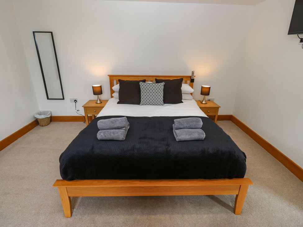 A bedroom with a bed and bedside tables at Upper House Barn (Saddleworth) Delph