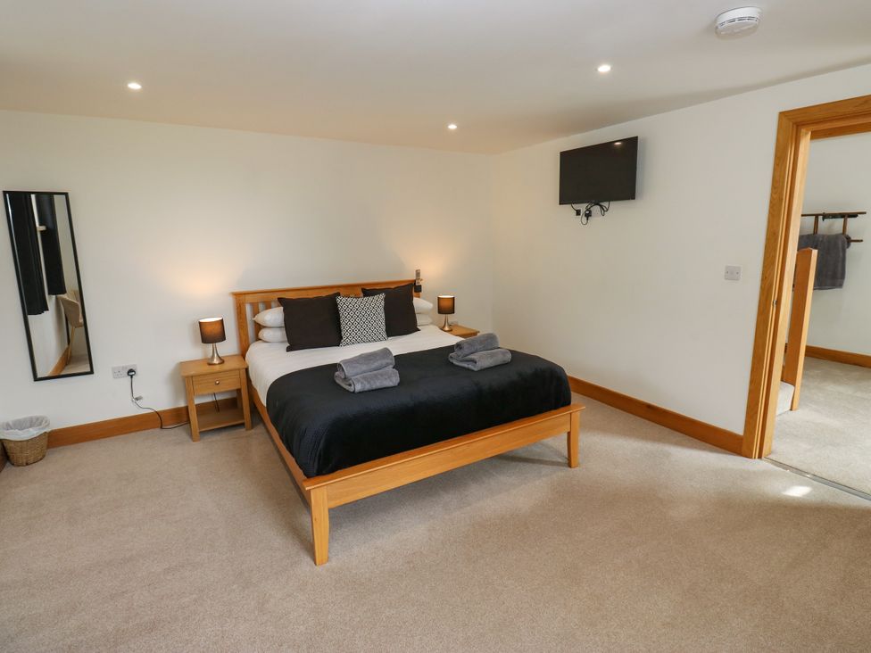 A bedroom with a bed and nightstand at Upper House Barn (Saddleworth) in Delph