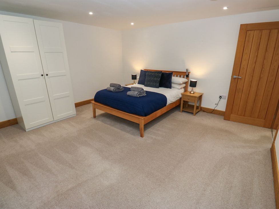 A bedroom with a bed and wardrobe at Upper House Barn in Delph