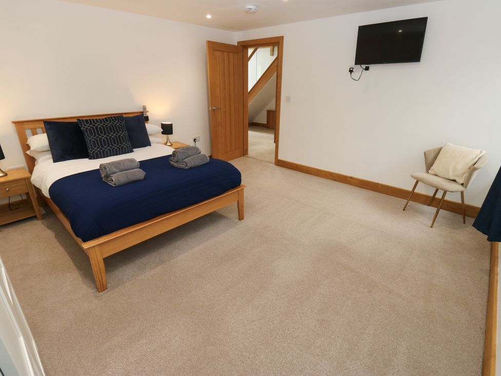 A bedroom with a bed and a chair at Upper House Barn in Delph