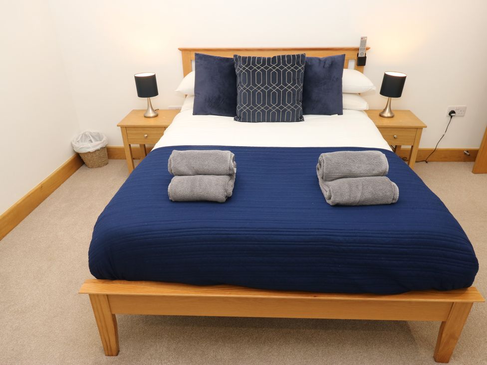 A bedroom with a bed and bedside tables at Upper House Barn (Saddleworth) in Delph