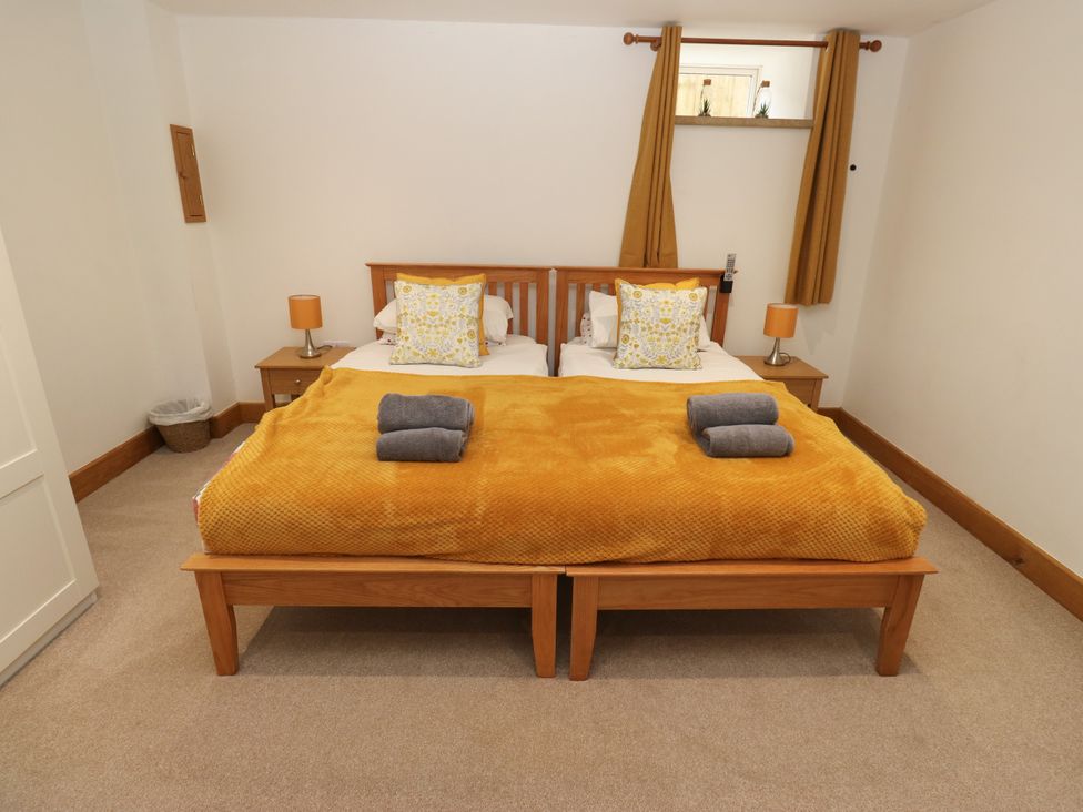 A bedroom with a double bed and nightstand at Upper House Barn (Saddleworth) Delph