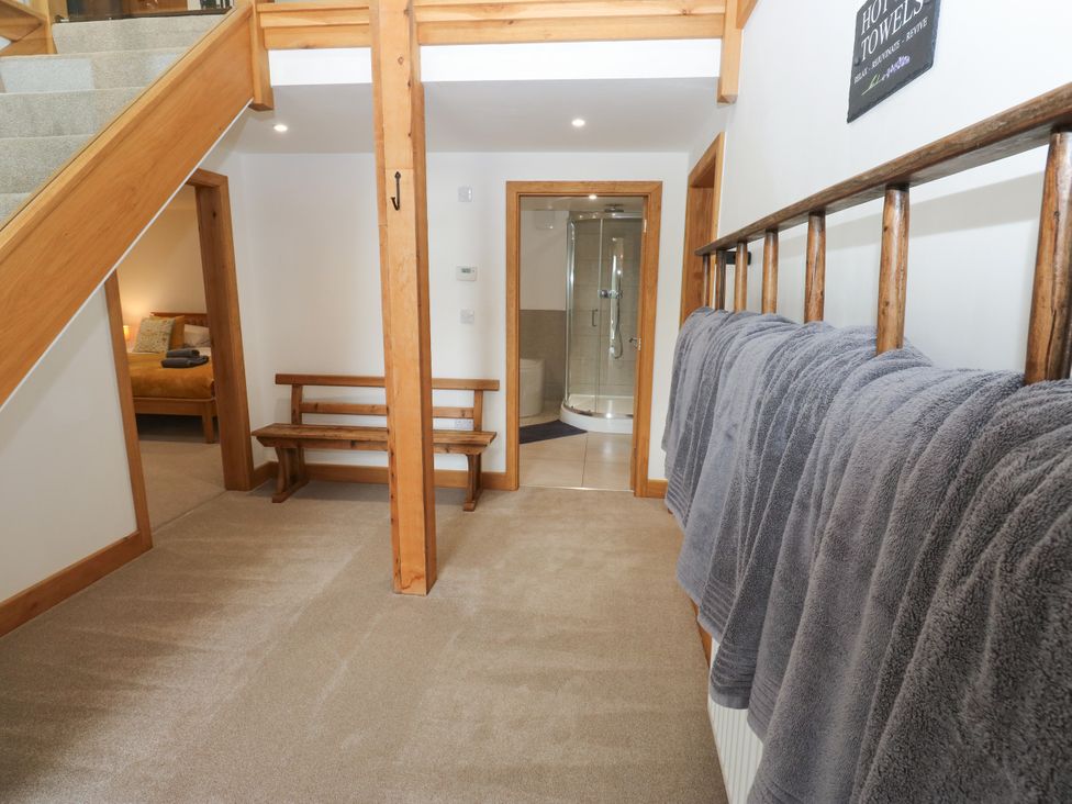 A hallway with towels on a rail and a bench at Upper House Barn (Saddleworth) in Delph