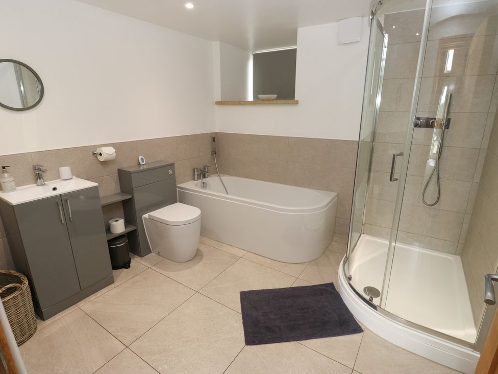 A bathroom featuring a bathtub, shower, toilet, and sink at Upper House Barn (Saddleworth) Delph