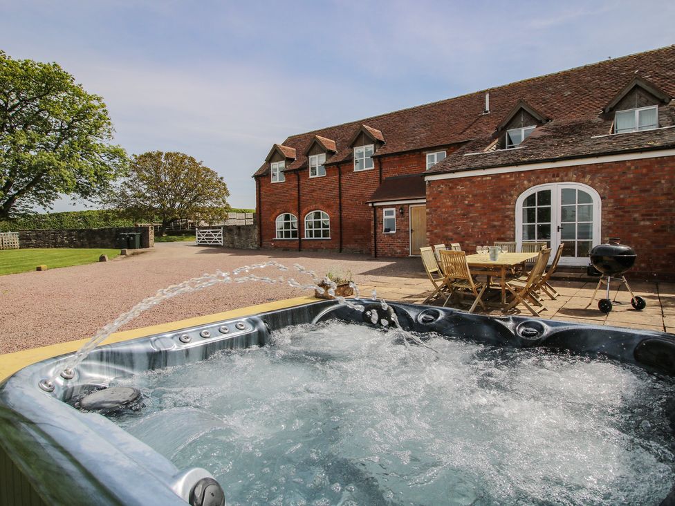 A hot tub and outdoor seating area at Hunters Moon Tenbury Wells