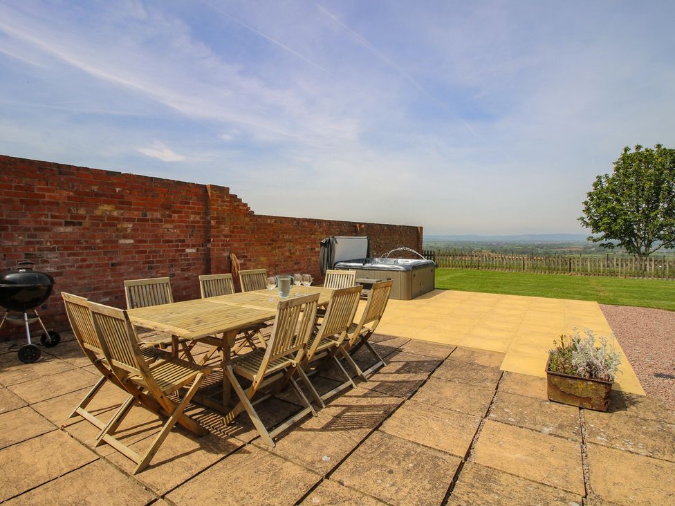 A garden with a dining table and chairs at Hunters Moon in Tenbury Wells