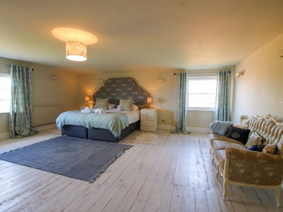 A bedroom with a bed and a sofa at Hilltop House in Tenbury Wells