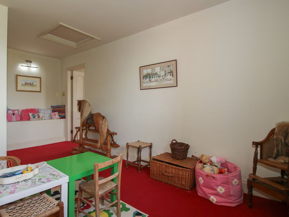 A playroom with a rocking horse and a colorful table at Hilltop House in Tenbury Wells
