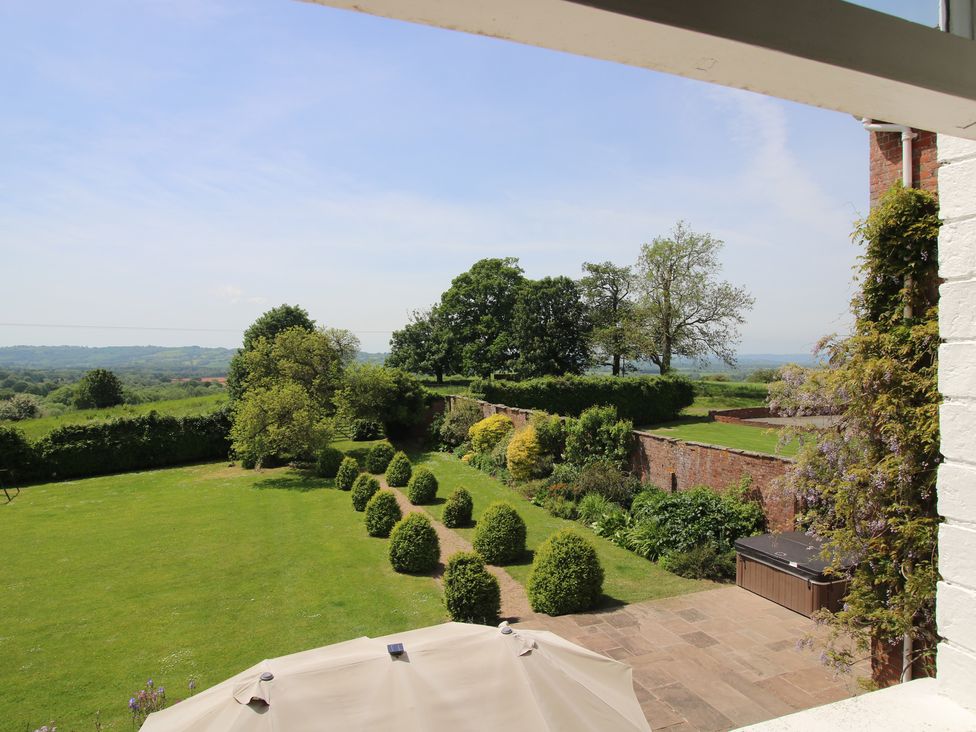 A garden view with trees and hedges at Hilltop House in Tenbury Wells