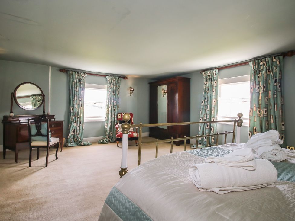 A bedroom with a bed and a dressing table at Hilltop House Tenbury Wells