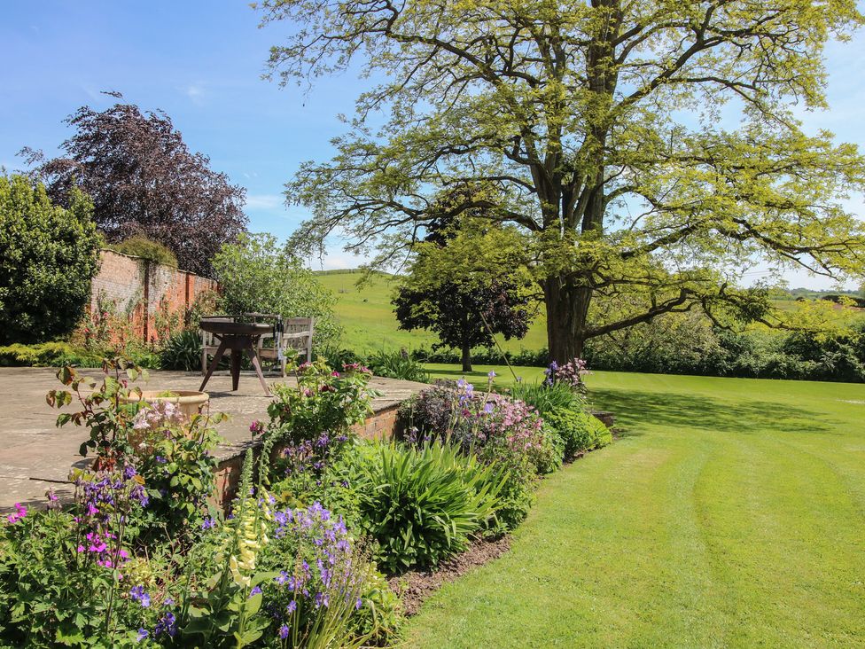A garden with a seating area and flowers at Hilltop House Tenbury Wells