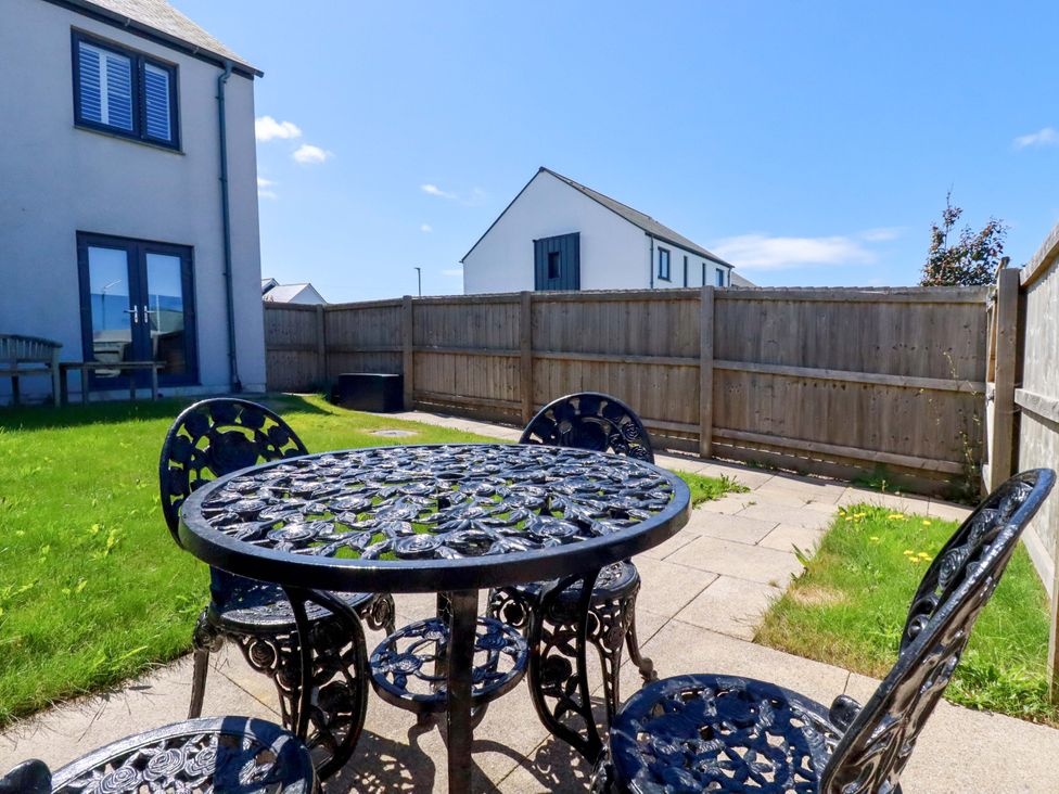 A garden with a table and chairs at The Sand Dunes in Crantock