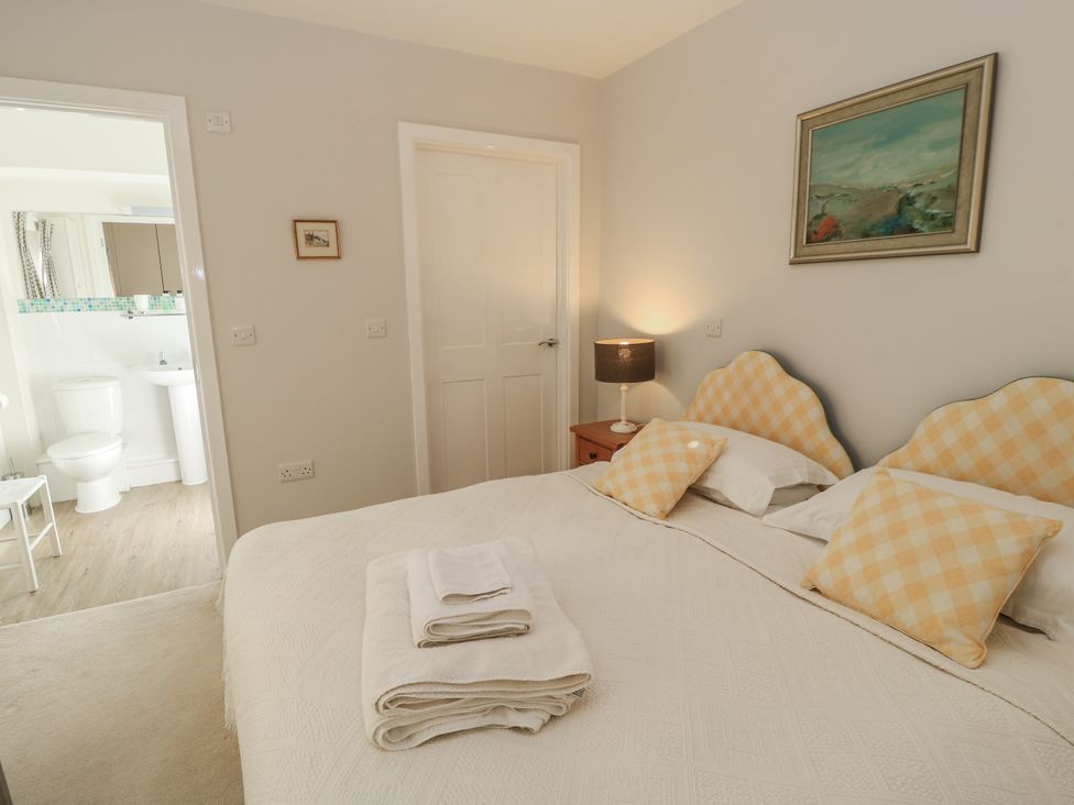 A bedroom with a bed and adjoining bathroom at Keepers Cottage in West Knoyle