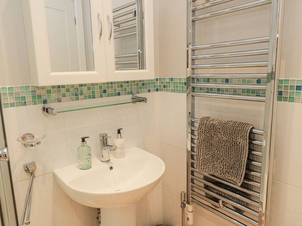 A bathroom with a sink, mirror, and towel rail at Keepers Cottage in West Knoyle